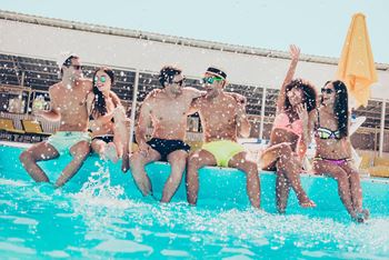 Young teens sitting on the edge of pool while splashing water at Renaissance Park Apartments, Davis, CA, 95618